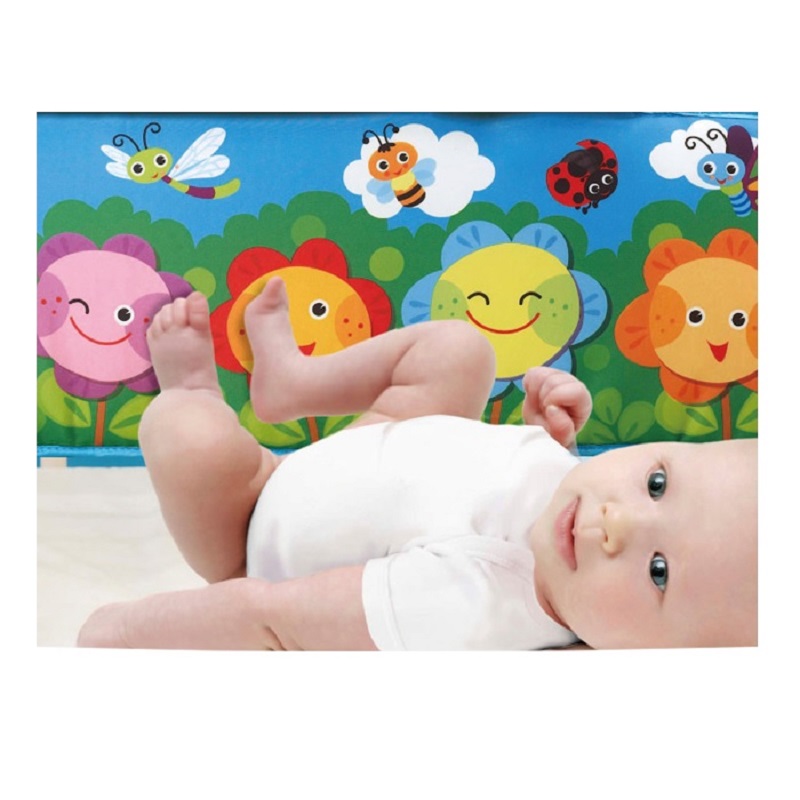 Baby interacting with sensory playmat features and overhead arches